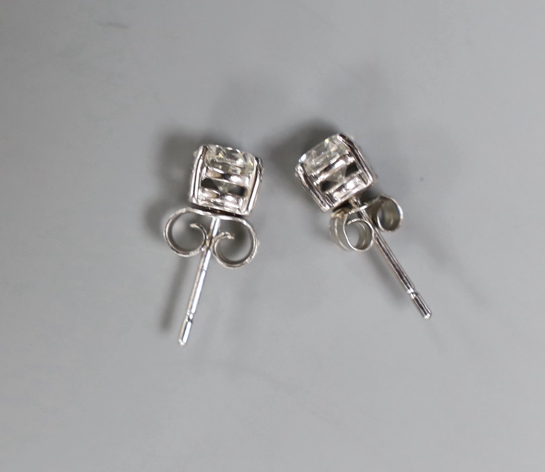A pair of modern 750 white metal and solitaire diamond set ear studs